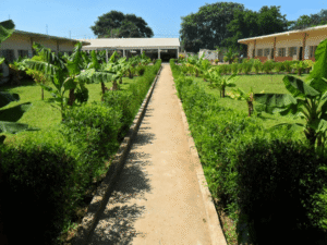 The official building and logo of Kairaba Upper Basic & Senior Secondary School in The Gambia
